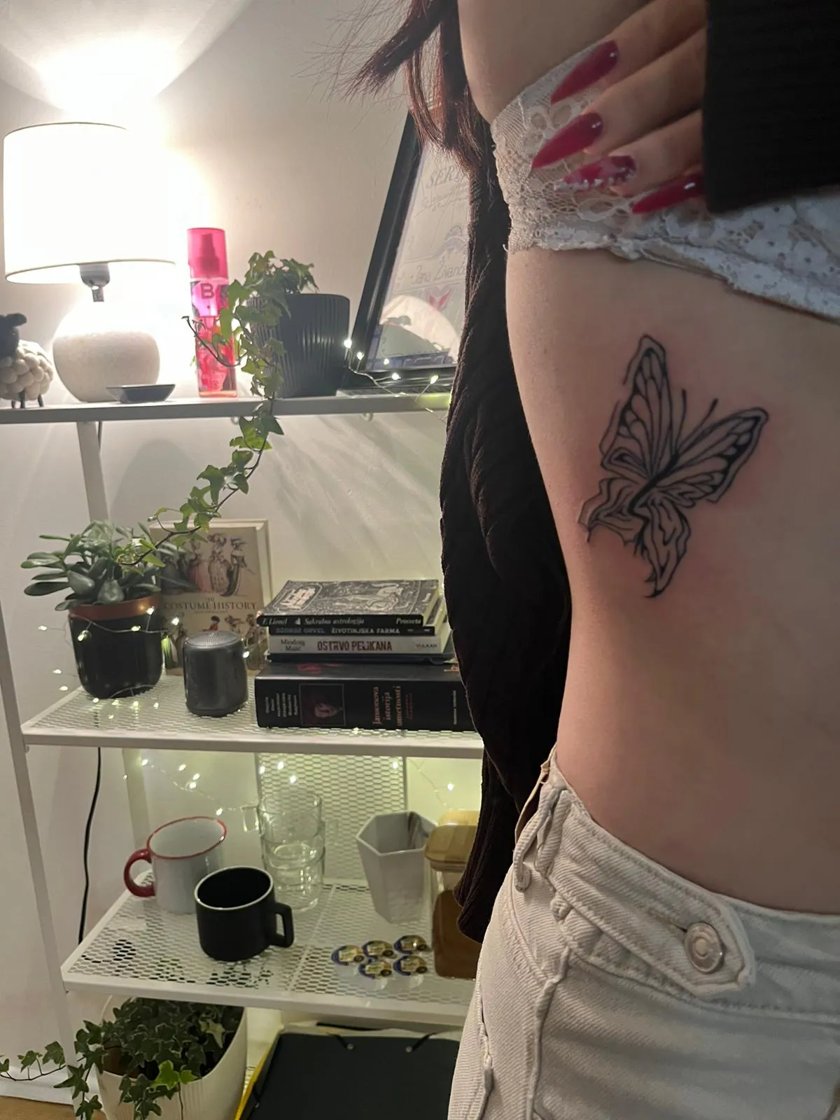 Fine-line tetovaža leptira na rebrima